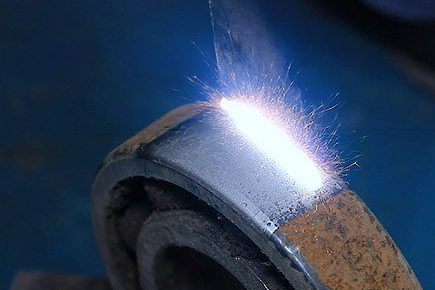 Funken sprühen von einem Laserreinigungsprozess auf einer Radlageroberfläche.