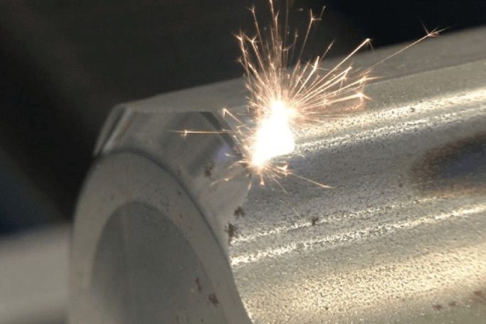 Funken sprühen von einem Metallstück während eines Bearbeitungsprozesses.